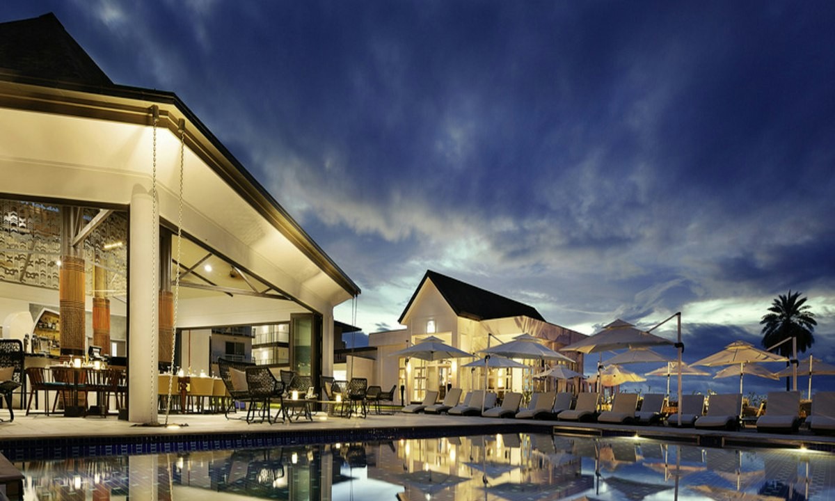 Luxury hotel pool and terrace at dusk with warm lighting