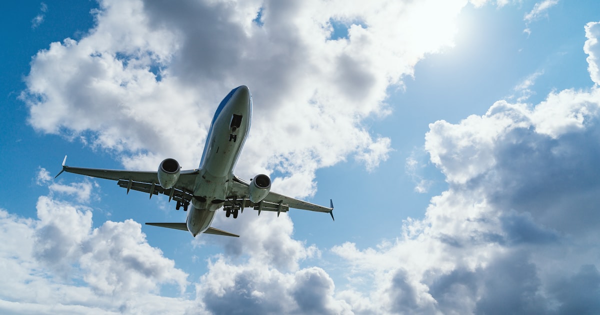 Airplane in flight — blue sky overhead — generic airline travel