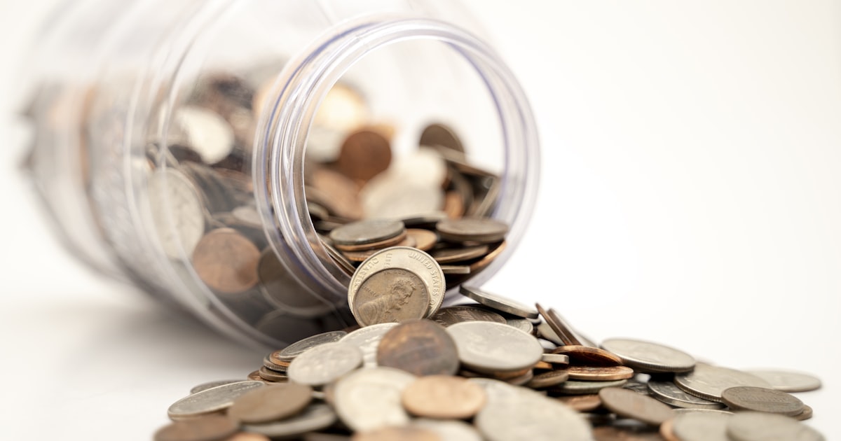 Coins in a jar — cash back savings and annual fee comparison