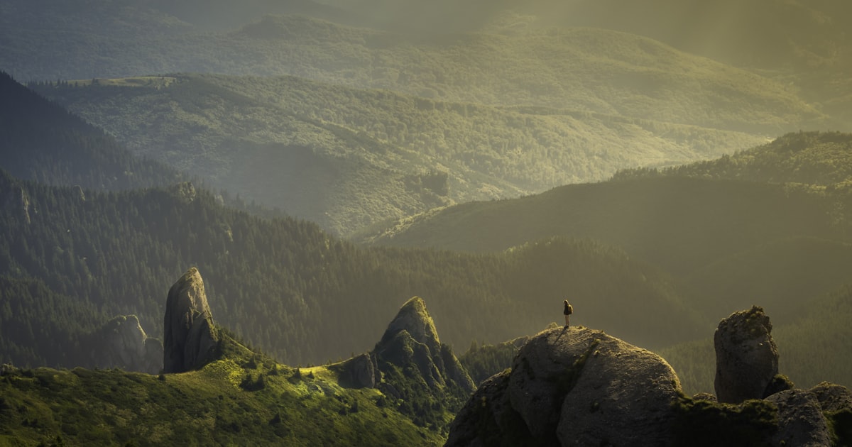 Traveler standing on mountain peak overlooking scenic valley